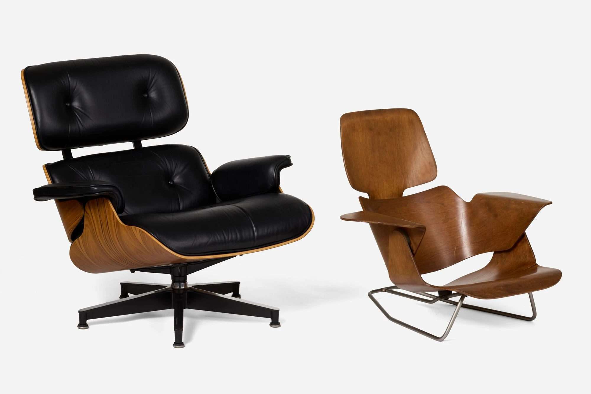 Angled side view of an Eames Lounge Chair circa 1976, featuring molded Palisander rosewood alongside an early prototype.