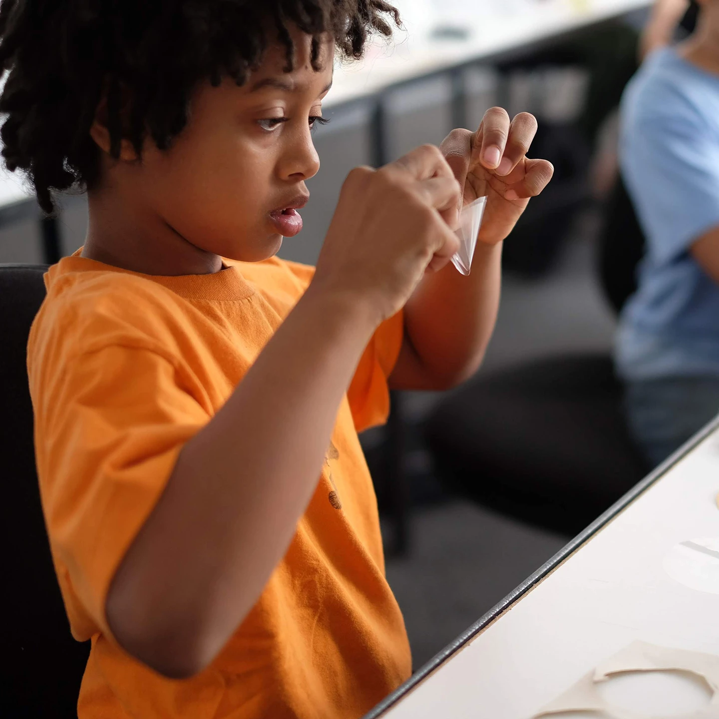 Inneract Project design student reviewing a paper prototype he made at a Youth Design Academy event.