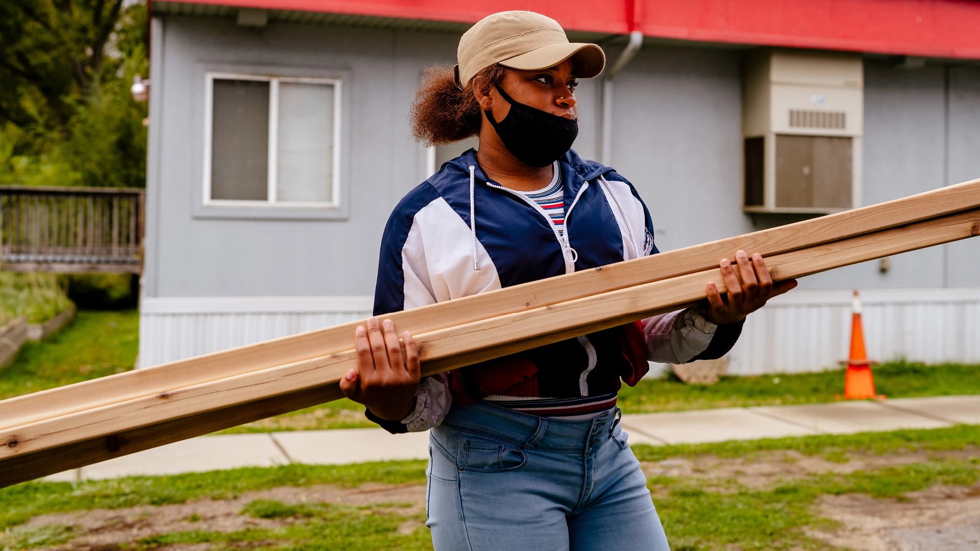 Student at the Brightmoor Maker Space carrying large pieces of lumber outside the workshop.