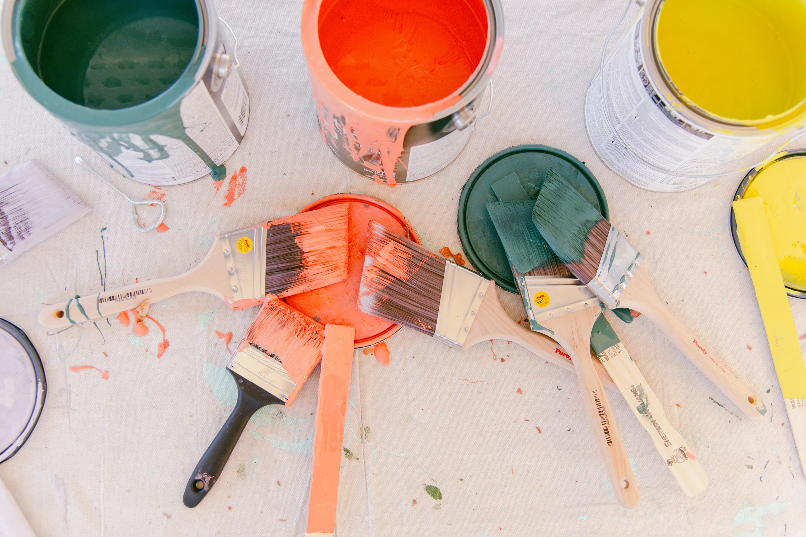 Several brightly colored paint can lids for Project Color Corps displayed on a table.