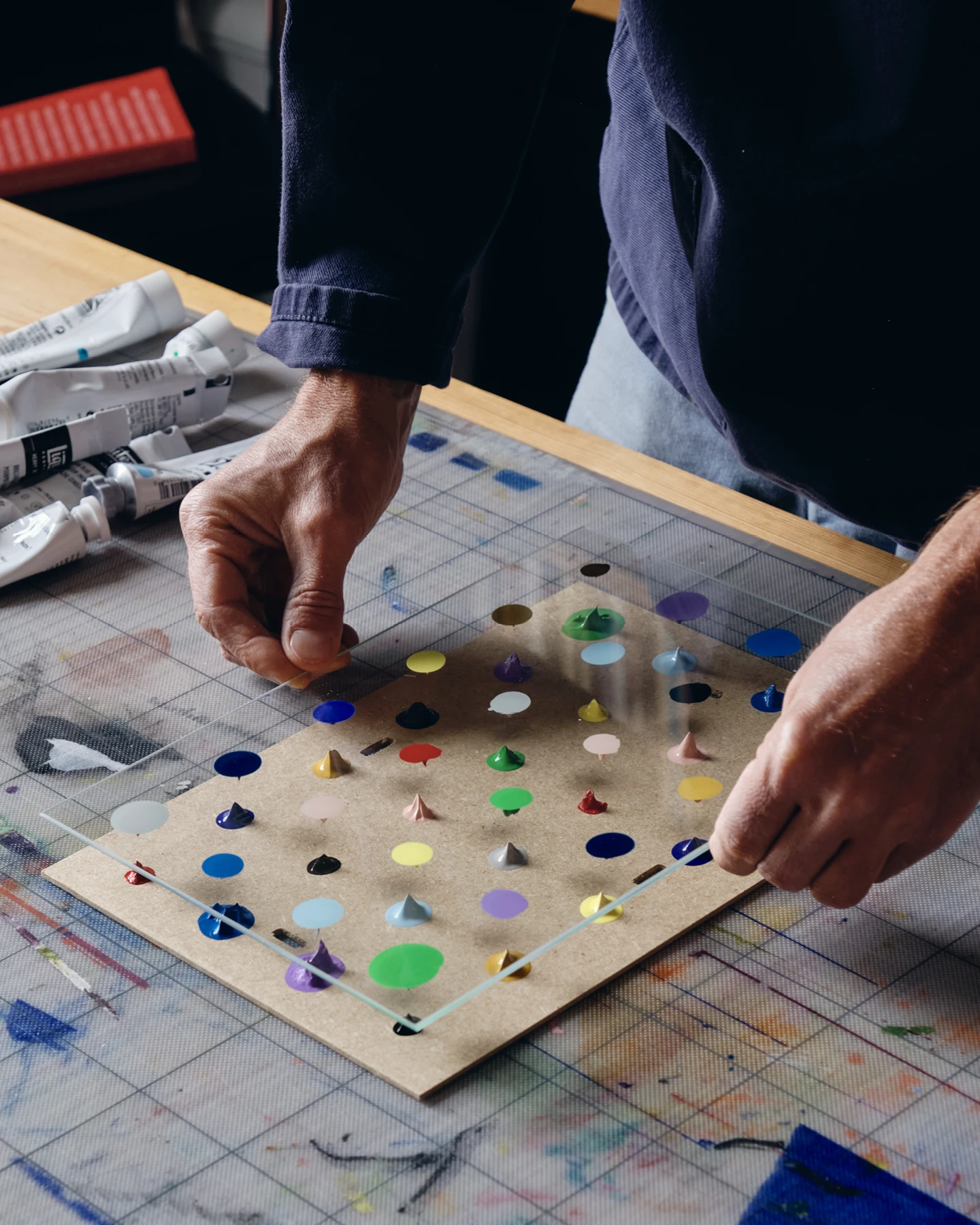 For Clip Frame Paintings, artist Daniel Eatock dabs paint, affixes the glass, adds more paint, and repositions the glass.