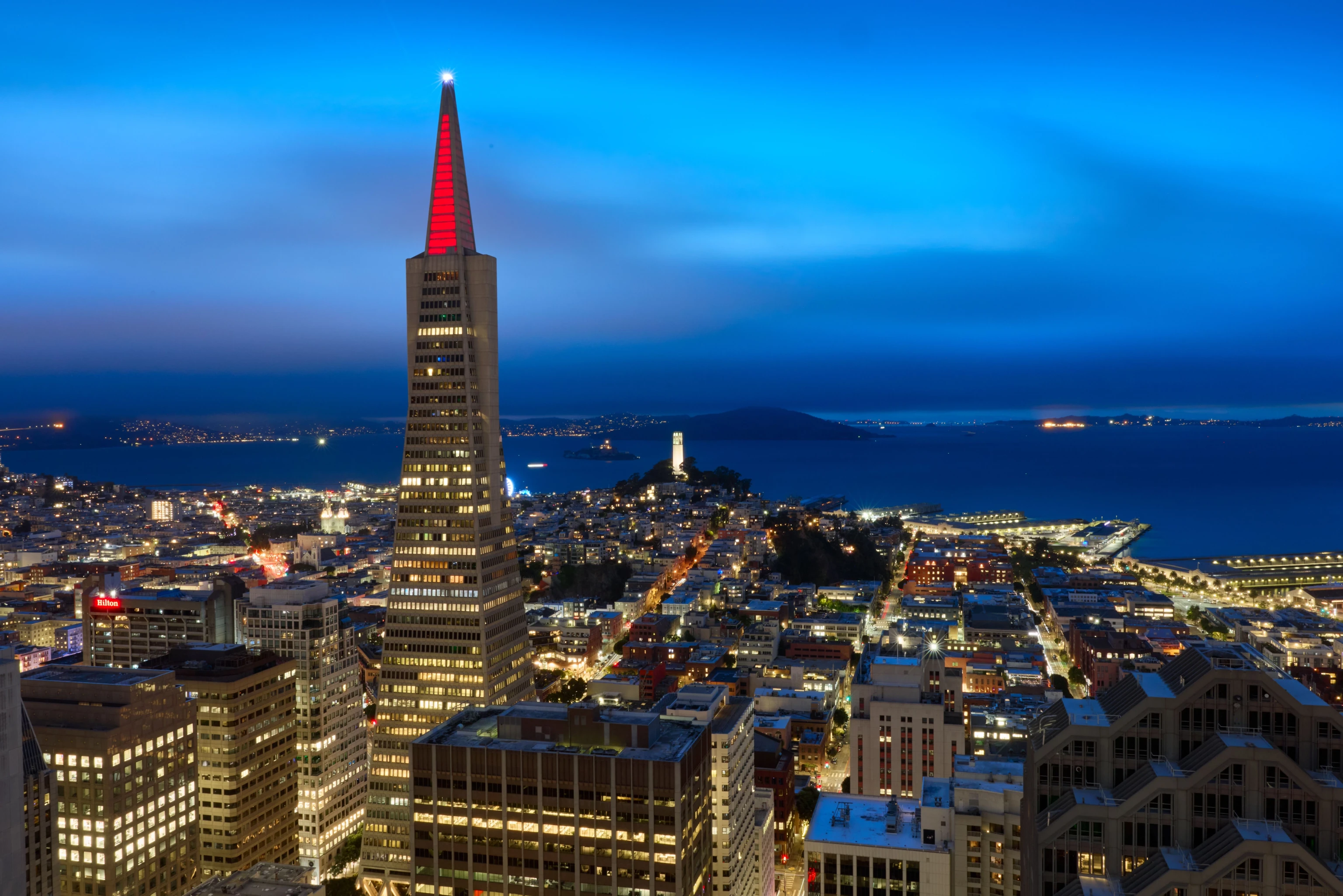 The Transamerica Pyramid building illuminated with red lights at the top in celebration of the Past as Prologue exhibition opening night.