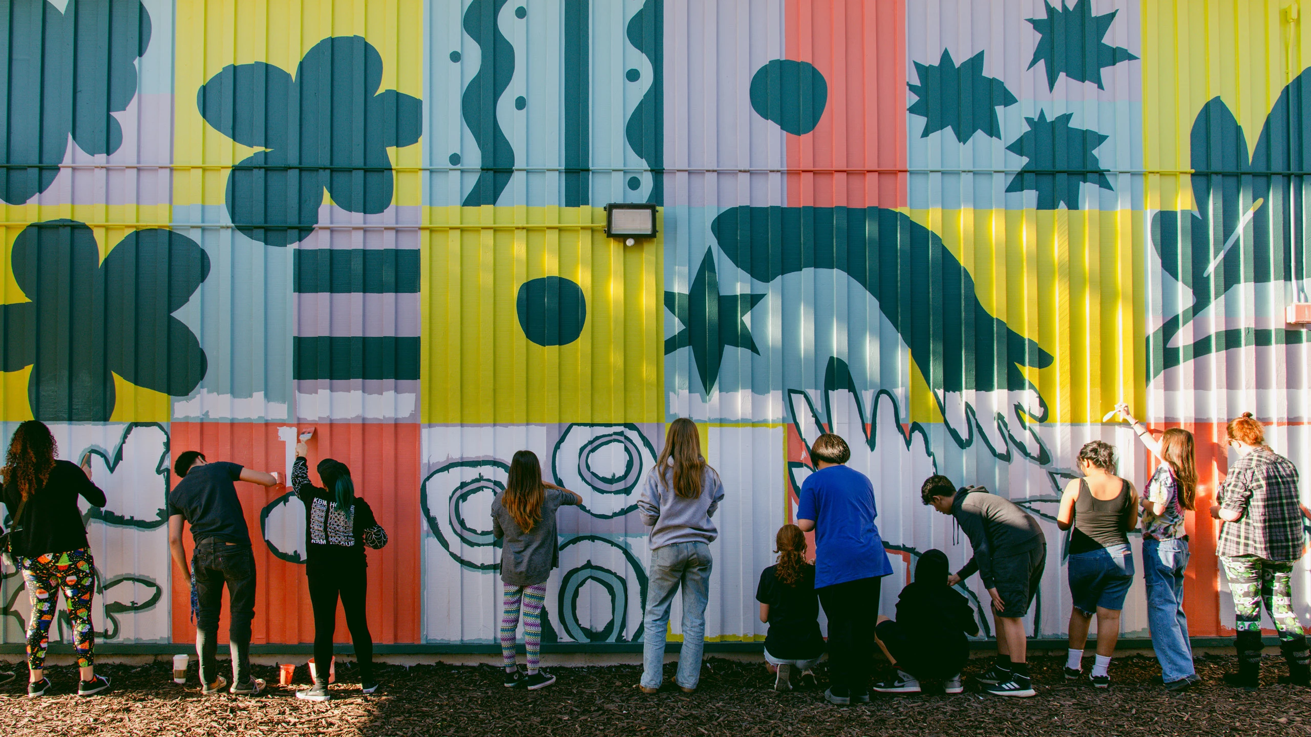 Students and Project Color Corps volunteers painting a mural at El Dorado Middle School, in Concord, California.
