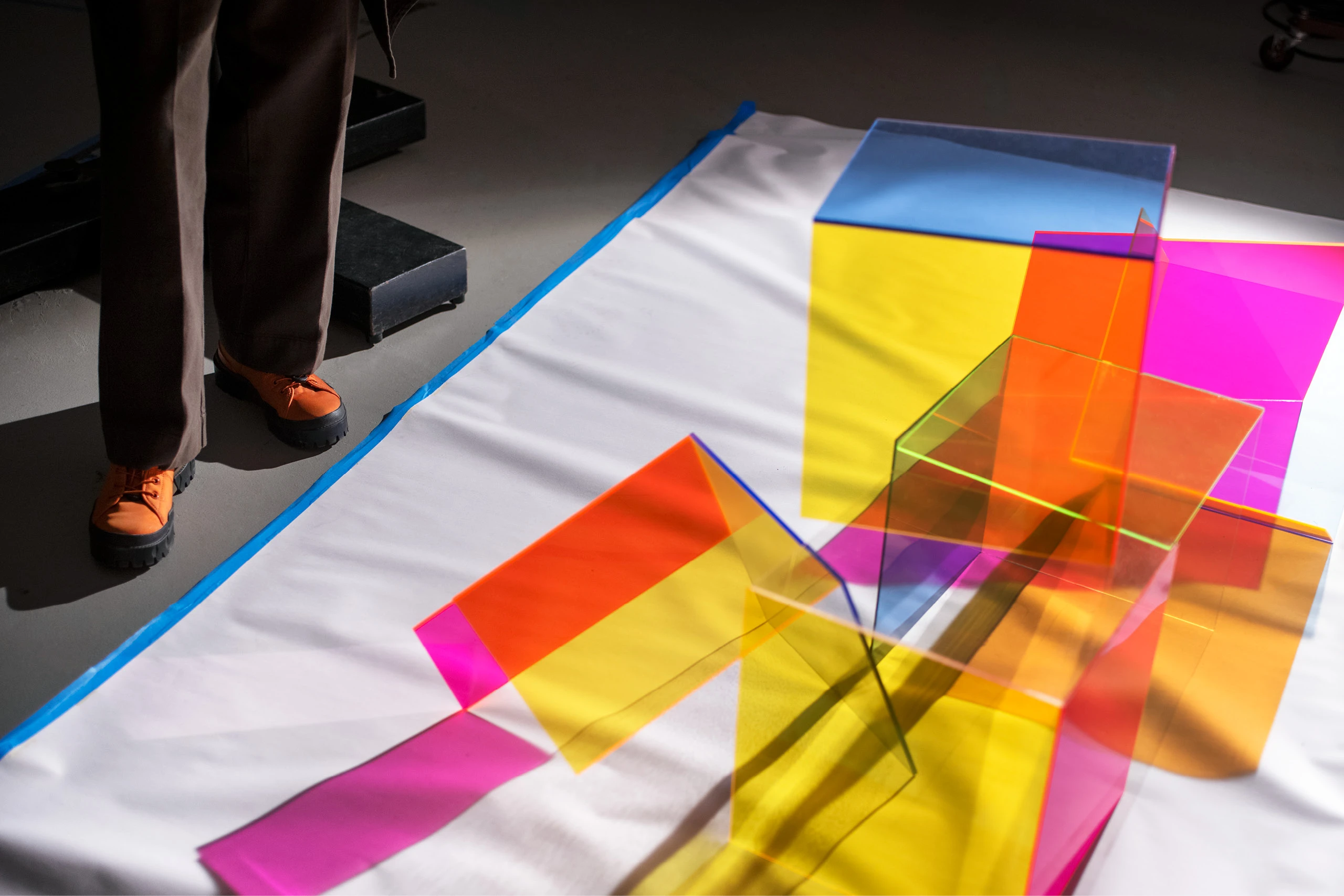 Multi-color neon plexiglass pieces arranged to cast colorful shadows in the studio of artist Barbara Kasten.