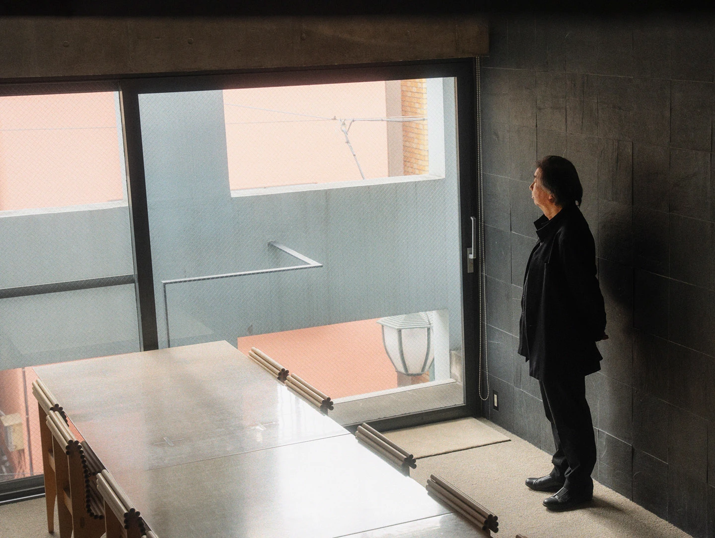 Shigeru Ban standing next to several Carta Chairs that he designed.