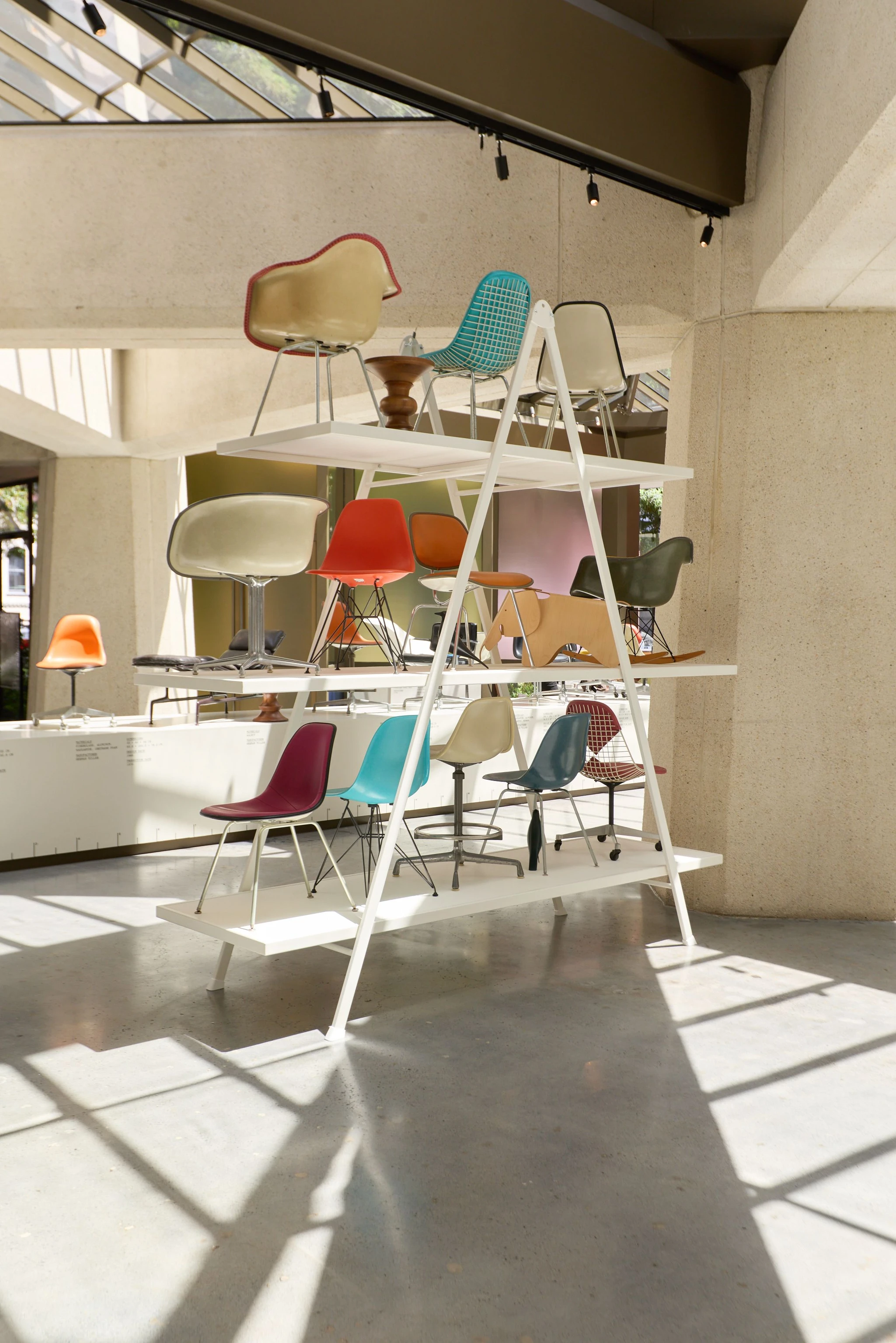 Pyramid shaped shelf display featuring many Eames chairs at the Past as Prologue exhibition at the Transamerica building in San Francisco.