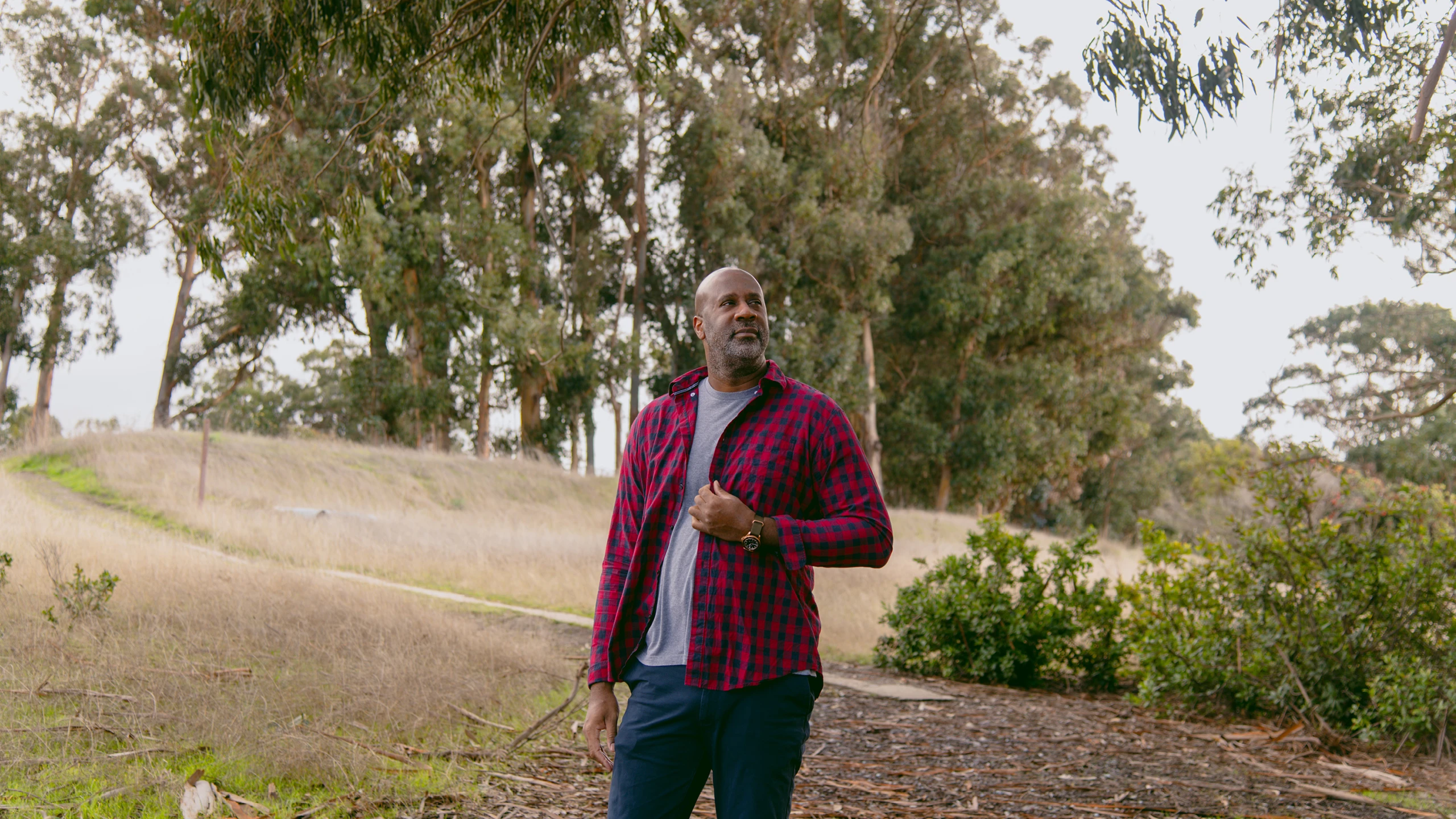 Maurice Woods, founder of design mentorship program—Inneract Project, standing in a field of trees.