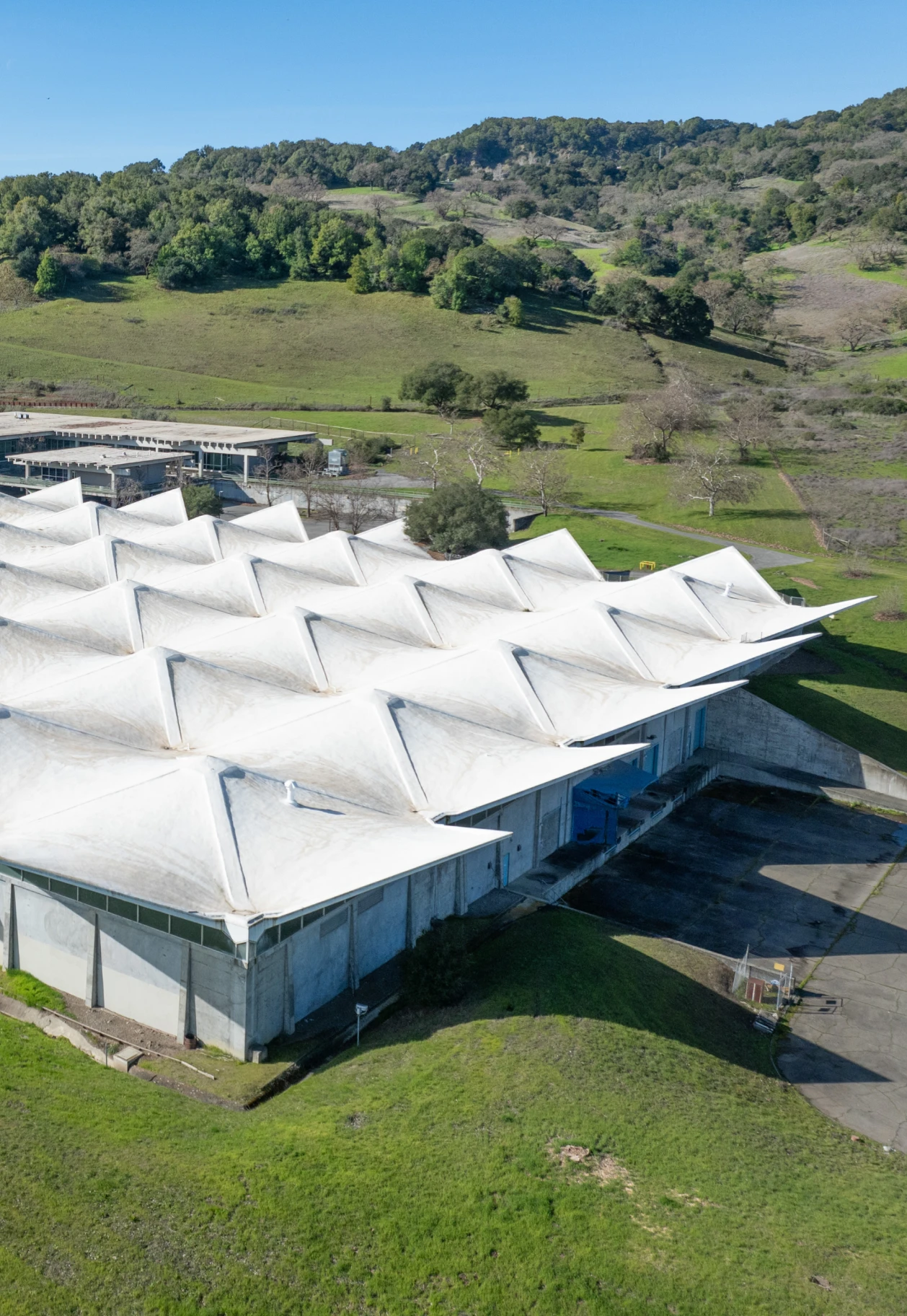 Top angled view of the hyperbolic concrete roof of the future Eames Institute museum, in Novato, California.