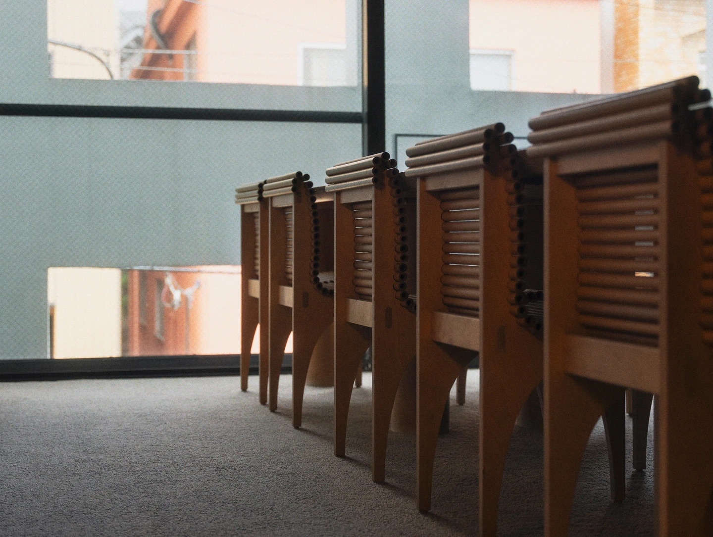 Chairs: Back view of several Carta Chairs made of plywood and small paper tubes, designed by Shigeru Ban.
