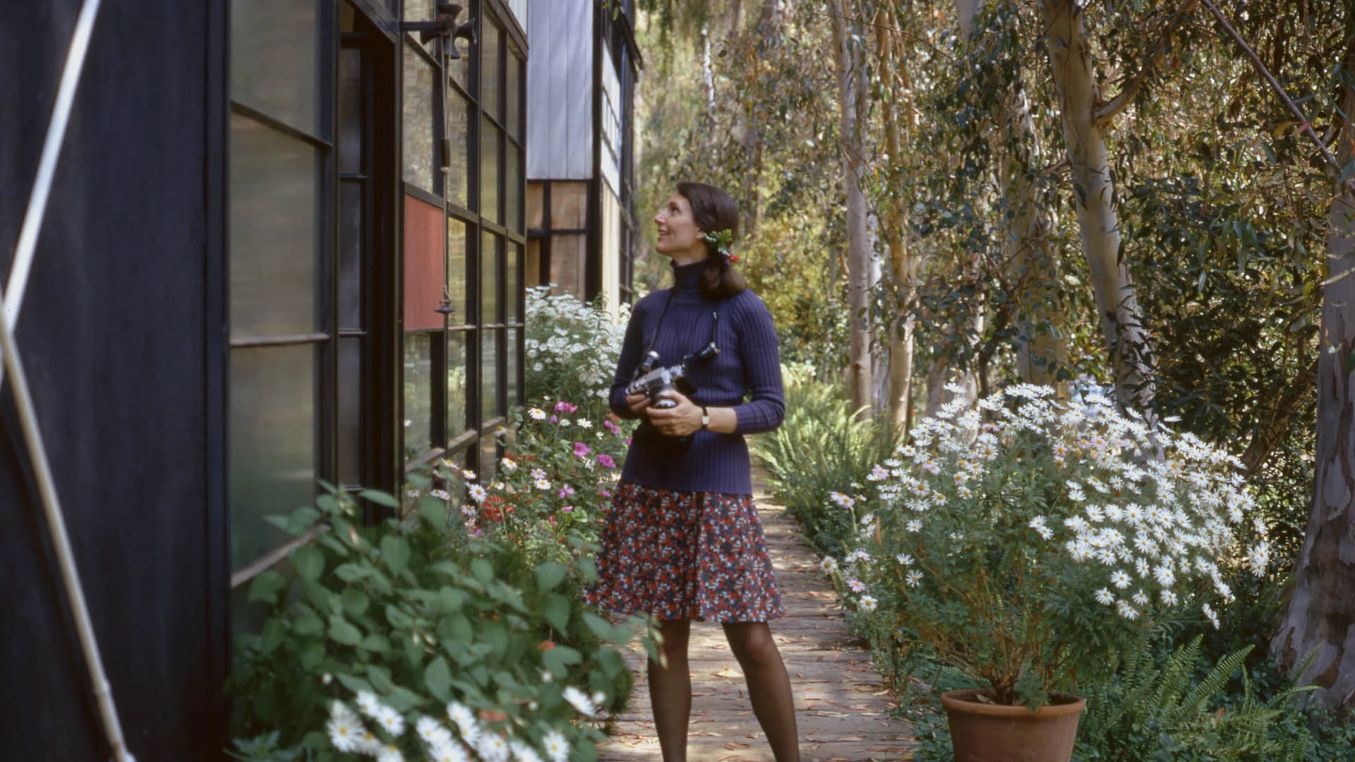 Lucia Eames as a young woman outside the Case Study House designed by Ray and Charles Eames, Kazam! Magazine.
