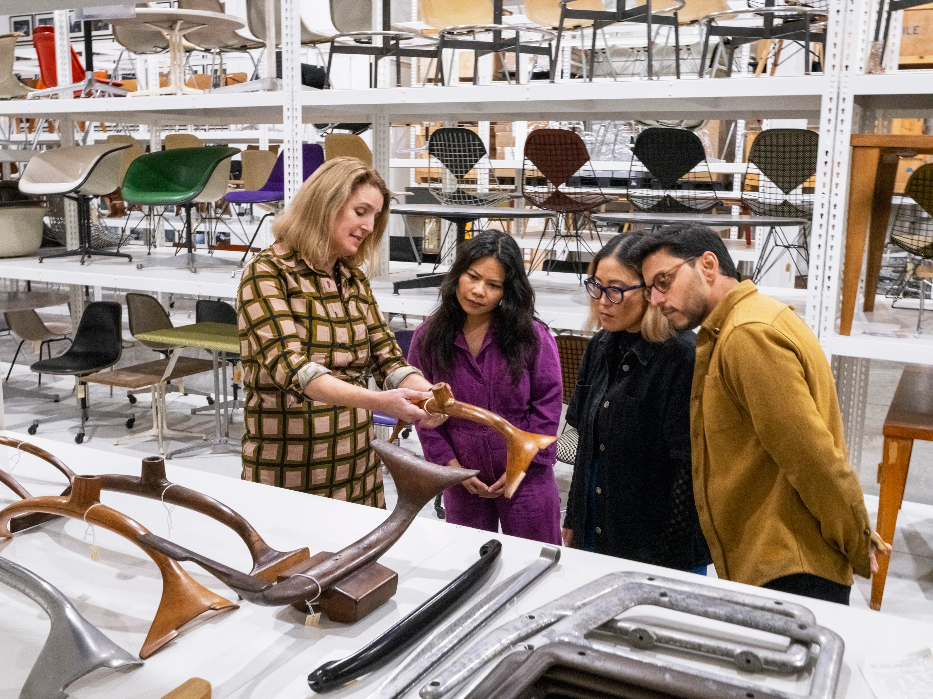 Interior of the Eames Archives with chief curator Llisa Demetrios giving a tour to a few guests while holding an artifact.
