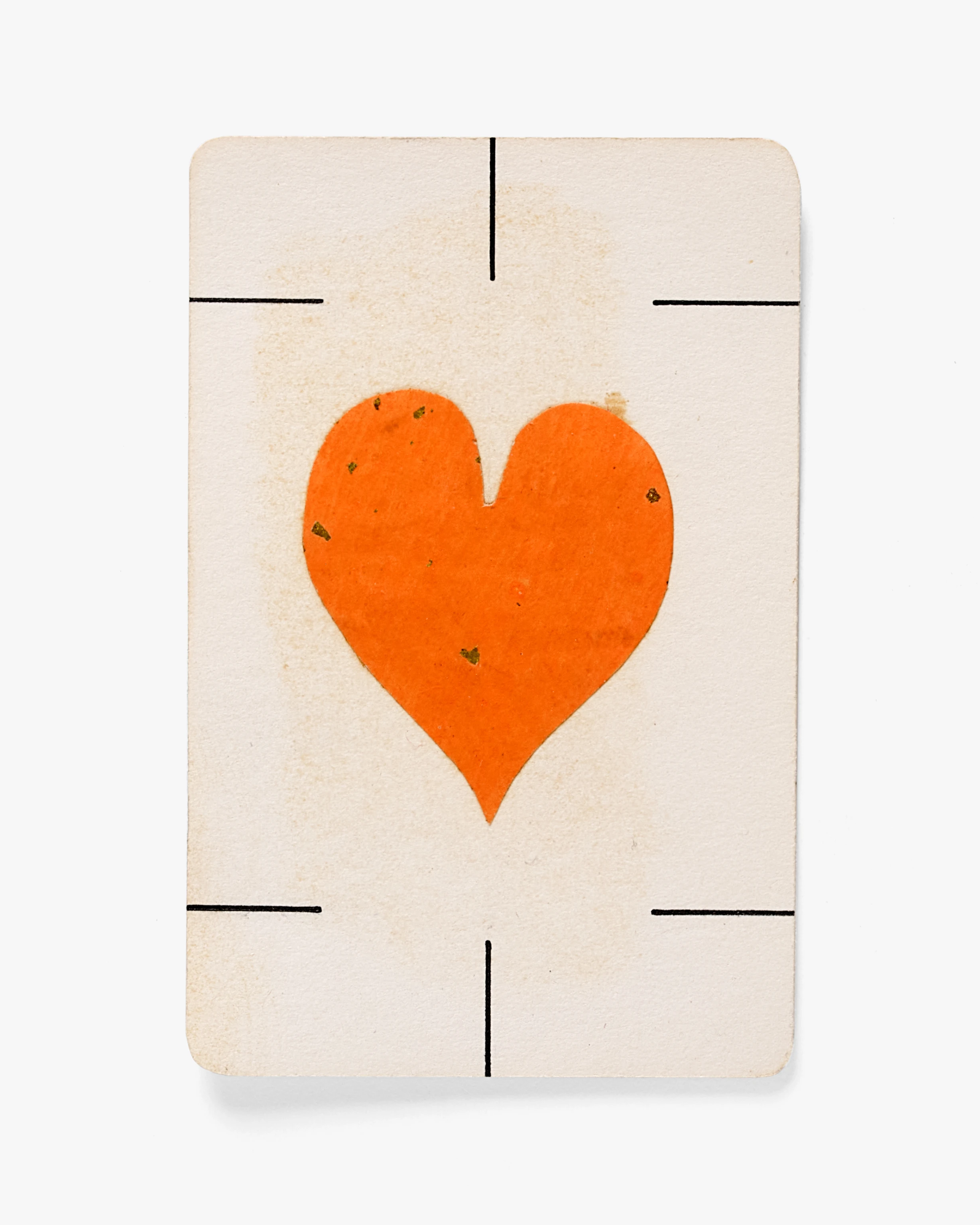 Photo of a playing card including a single red heart against a white background