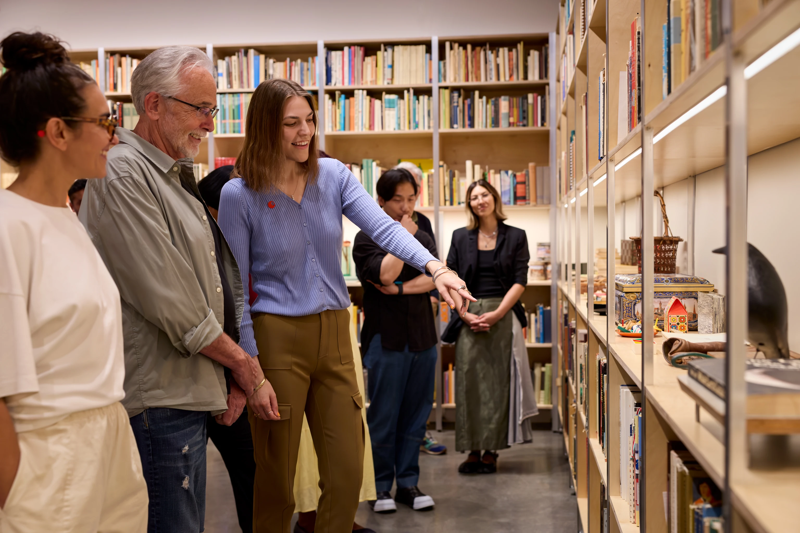 Visitors explore the Life Gallery at the Eames Institute, viewing the Eameses personal artifacts, books, and objects.