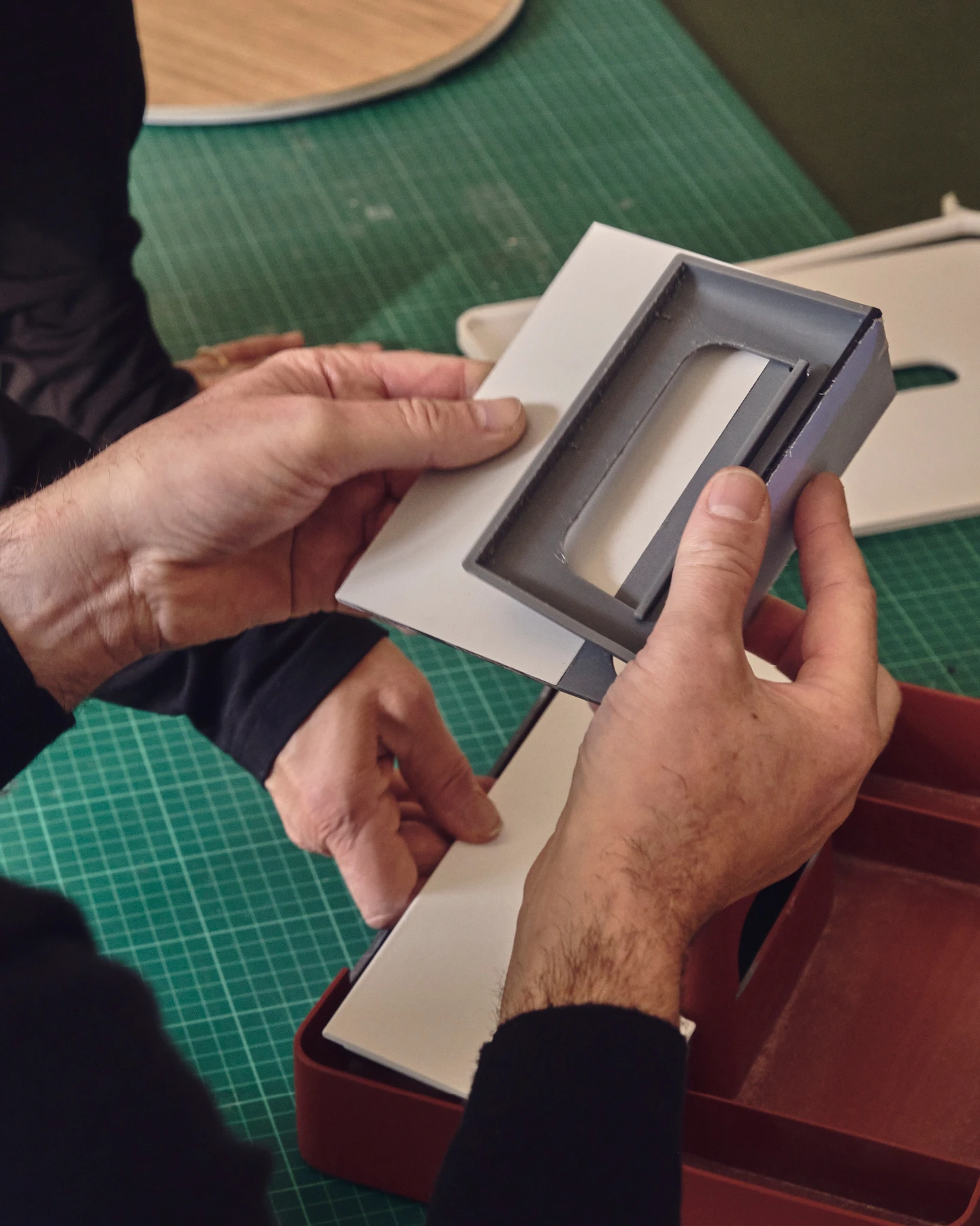Close up of Sam Hecht and Kim Colin’s hands holding design prototypes—Kazam! Magazine.