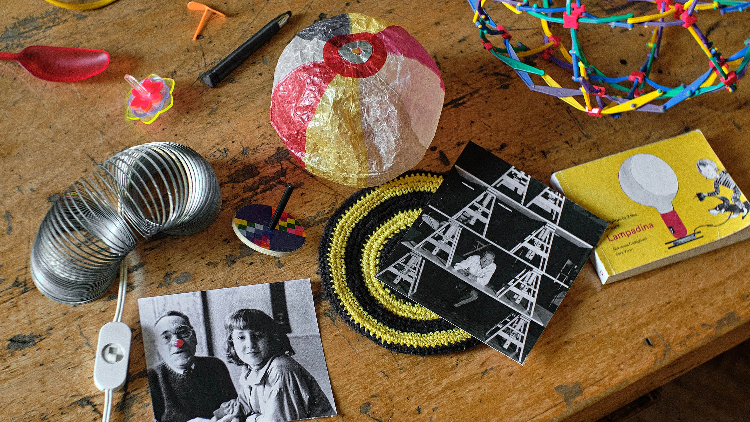 A table top at the Milan studio of Achille Castiglioni with several toys and a photo of him and his daughter Giovanna.