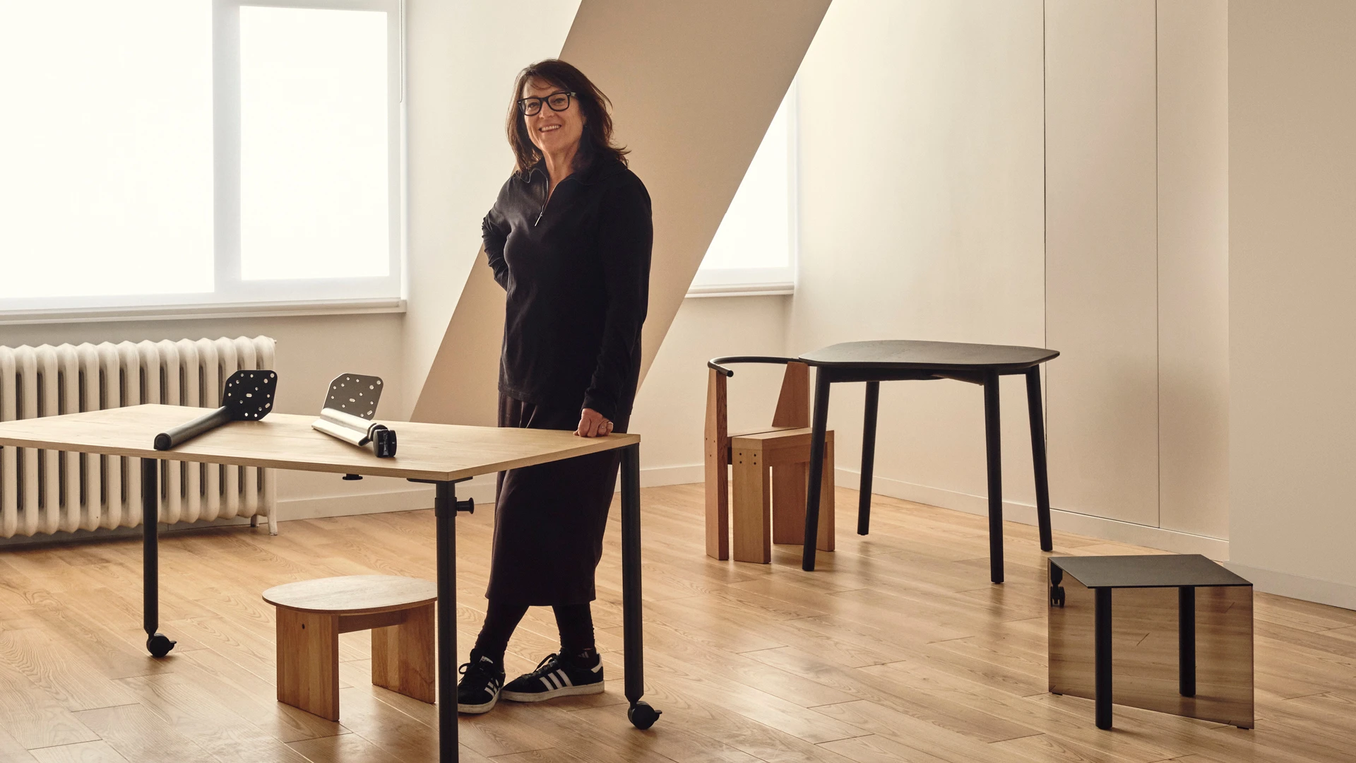Kim Colin of design studio Industrial Facility surrounded by tables designed for Fucina, Herman Miller, and Mattiazzi.
