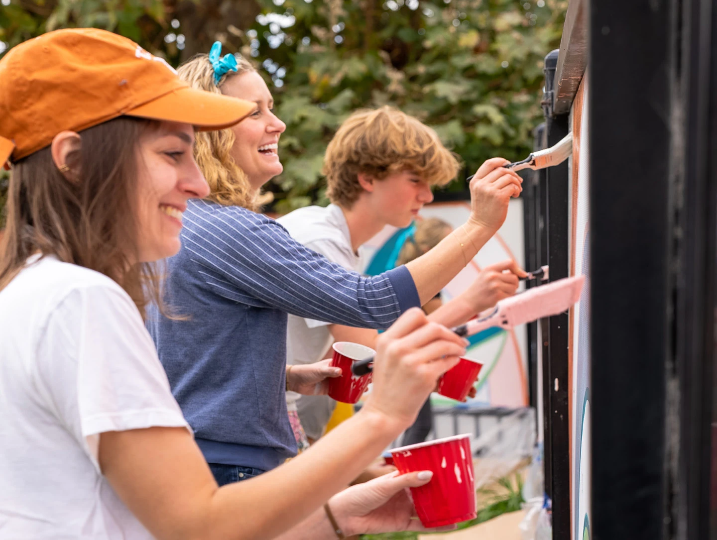 Students and volunteers paint the Hoover Elementary mural featuring natural motifs designed by Bay Area firms BAMO and SWA.