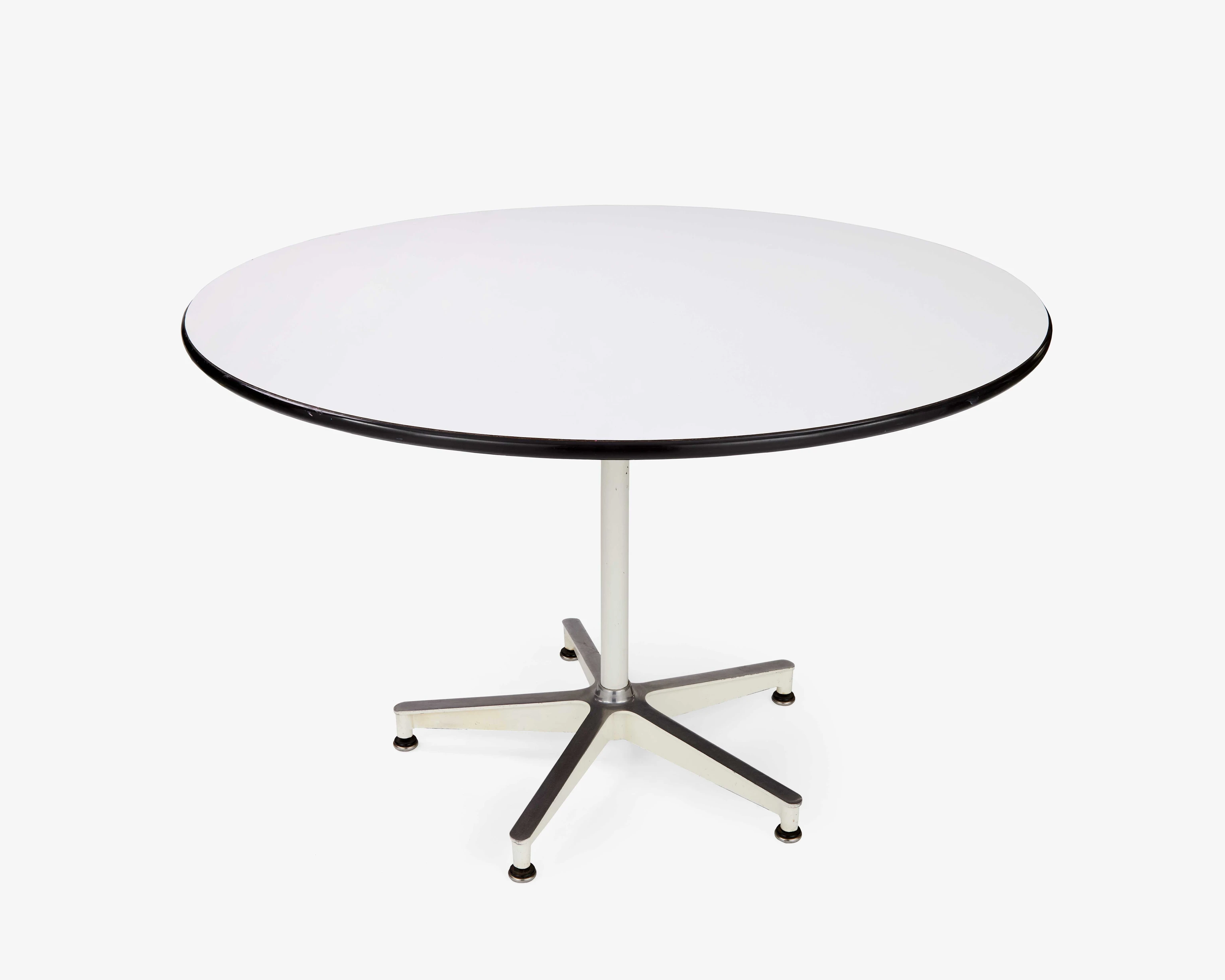 Front view of an Eames 650 Dining Table with a white laminate top, edged with dark grey vinyl, and a cast aluminum base.