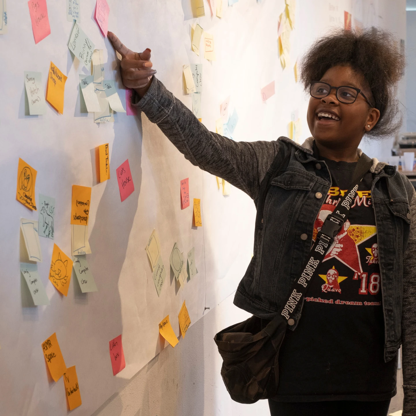 A student looks at a wall covered with design ideas during an Inneract Project Youth Design Academy, in San Francisco.