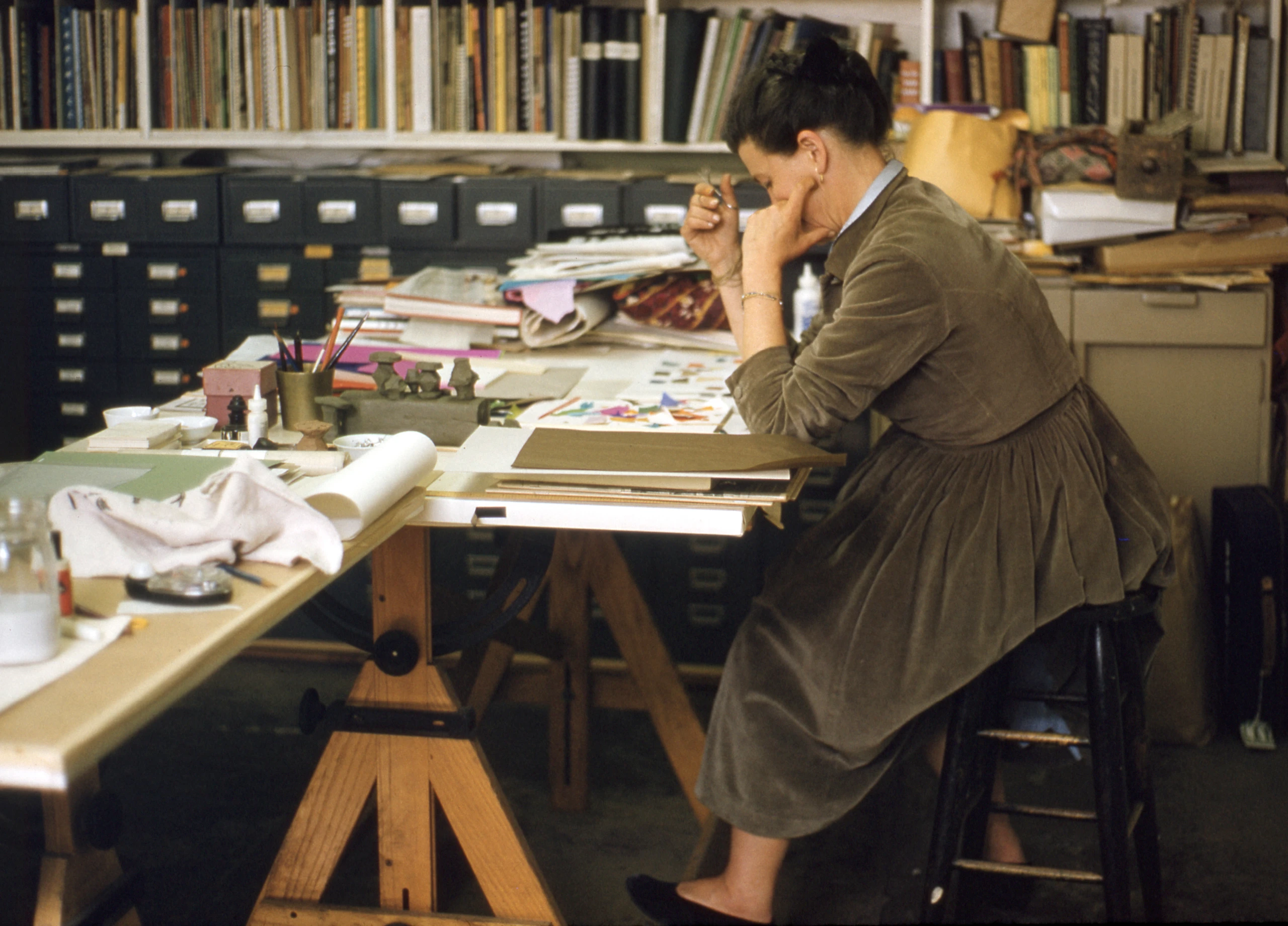 Designer Ray Eames, integral to all projects, at work in the Eames Office graphics room in 1960. Image © Eames Office, LLC
