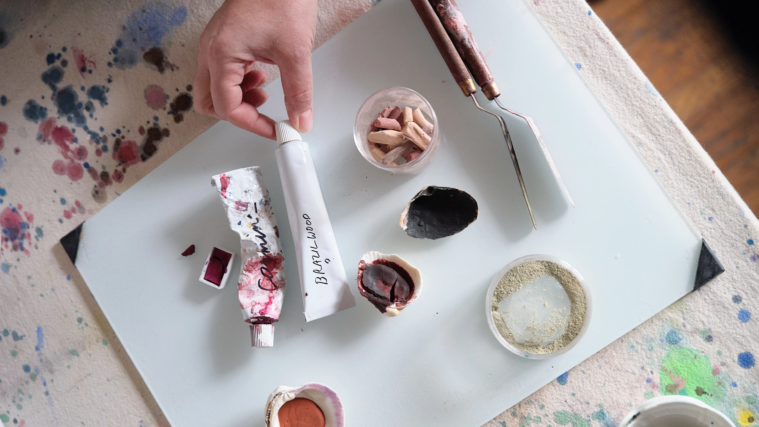Various pigments made by abstract artist Natalie Stopka are displayed on a work table.