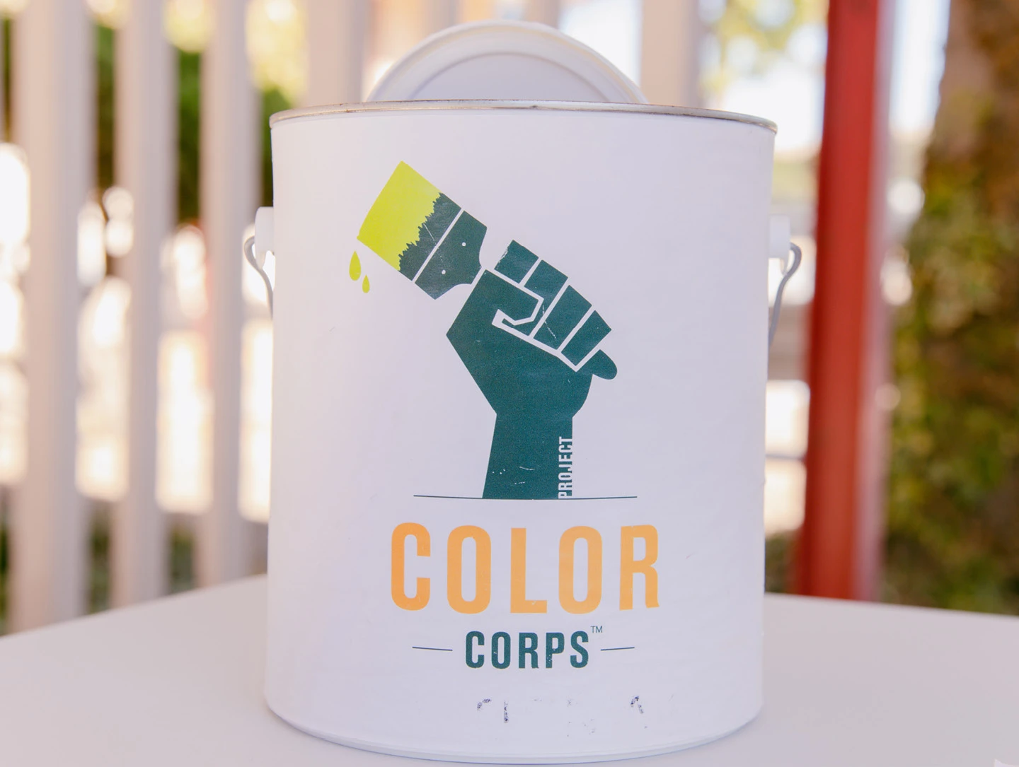 Paint gallon with the Project Color Corps logo on the front.