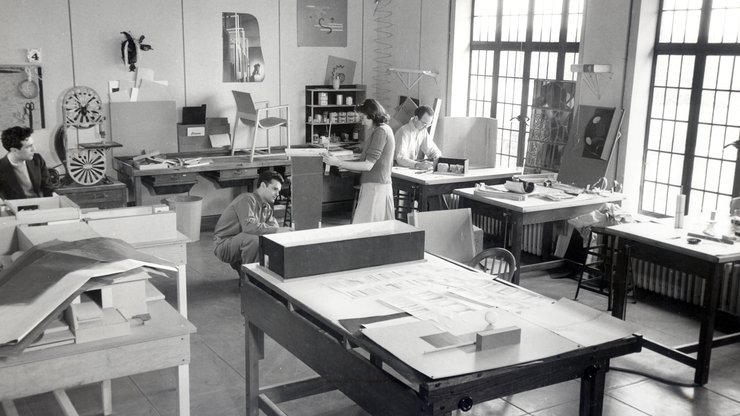 Charles Eames at work in Cranbrook’s Design Department alongside a chair that is a design for Kleinhans Music Hall, 1940.