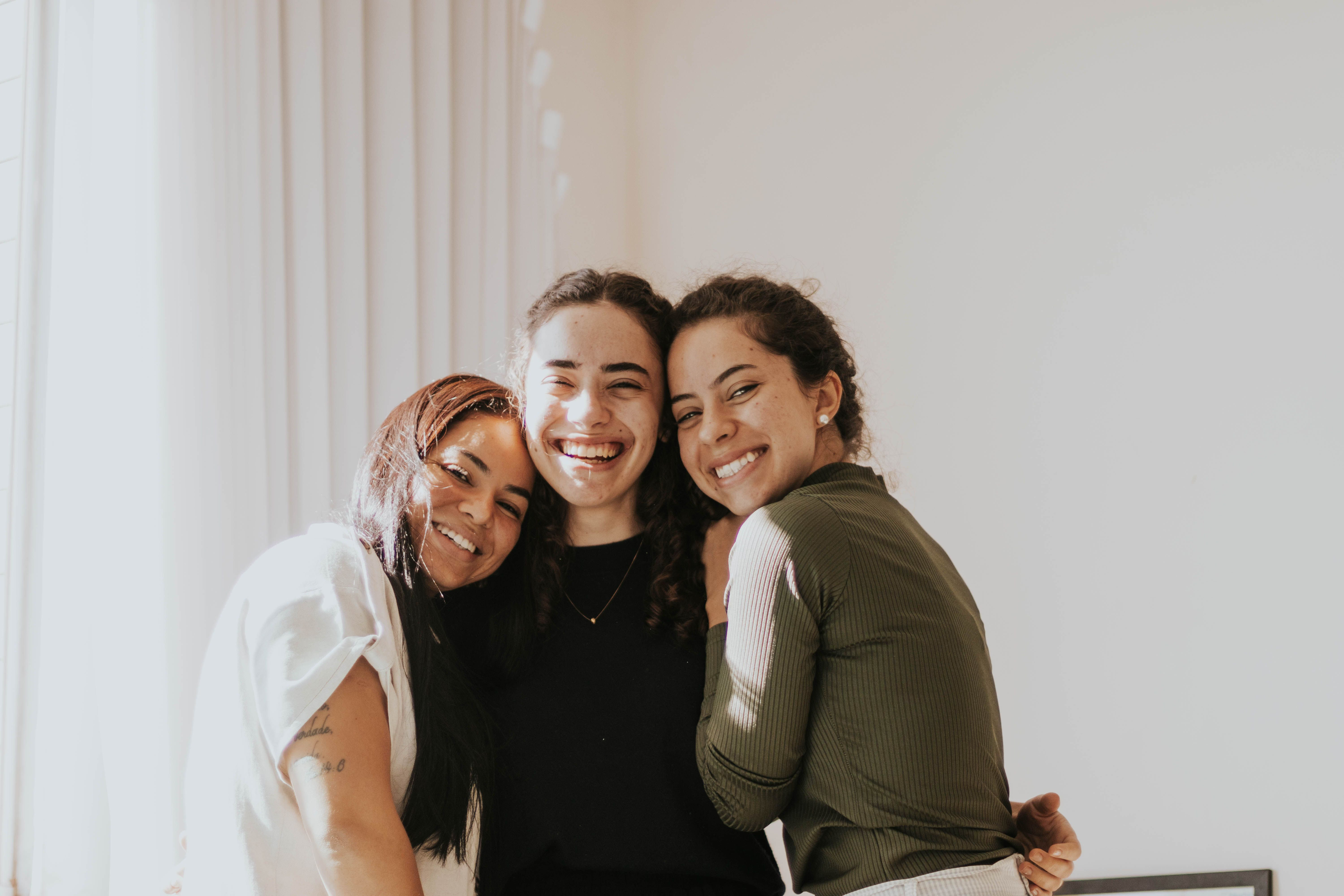 Three women embracing and smiling