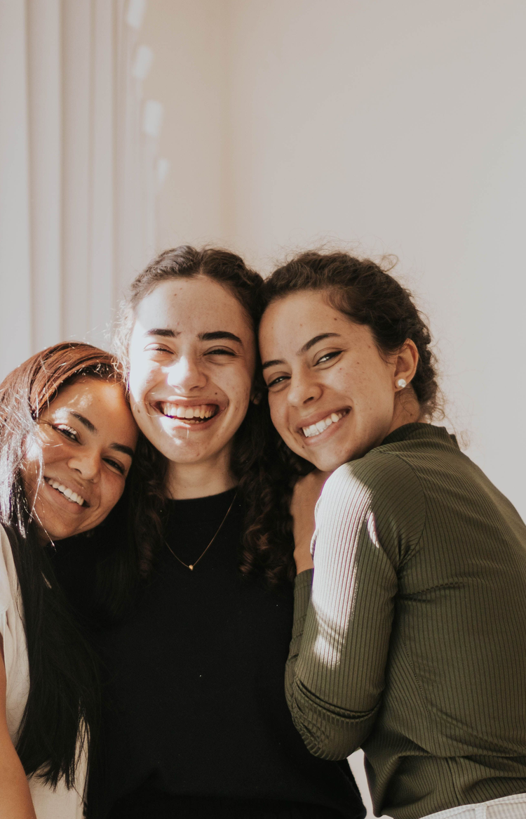 Three women embracing and smiling