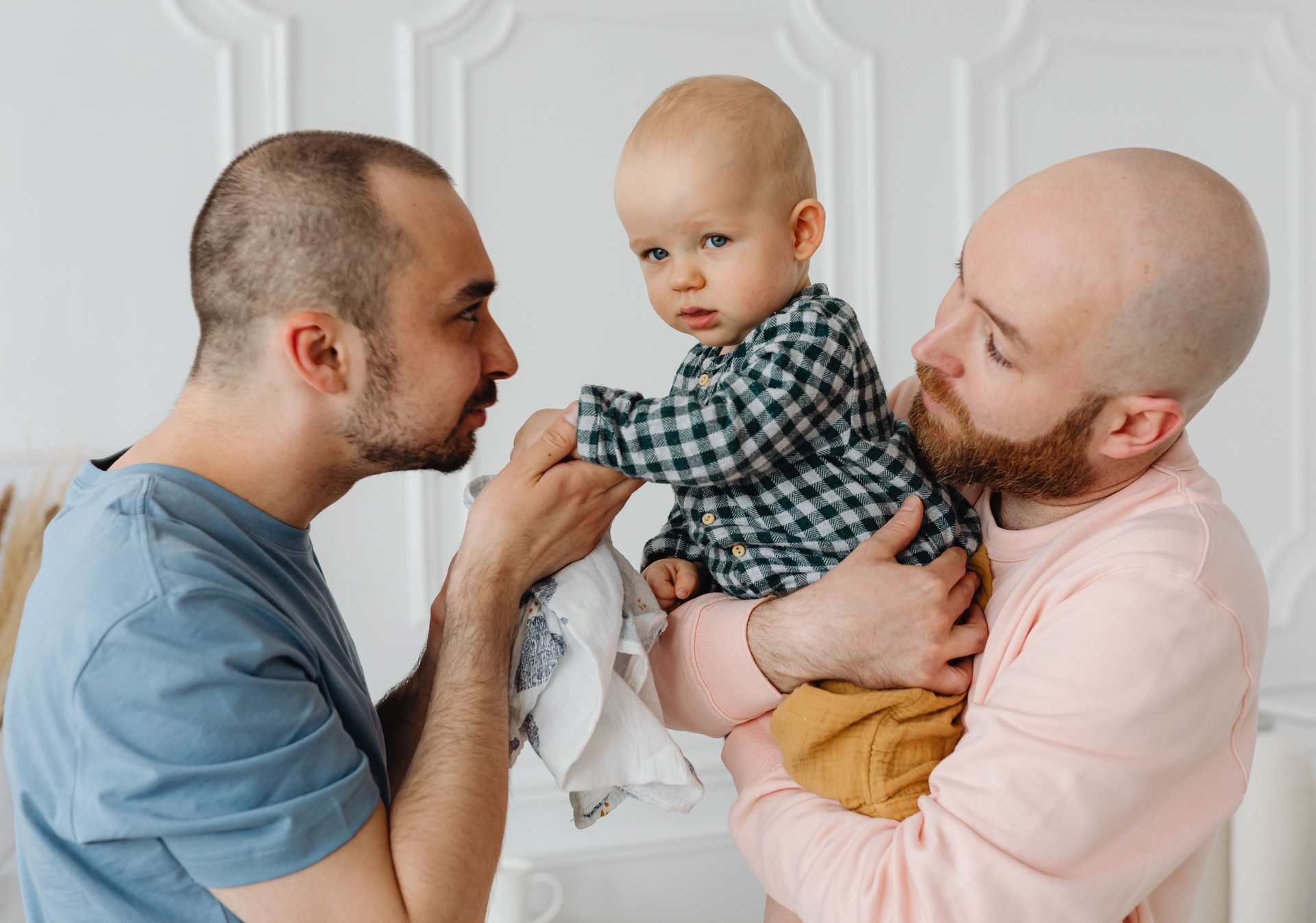 Two fathers holding their baby