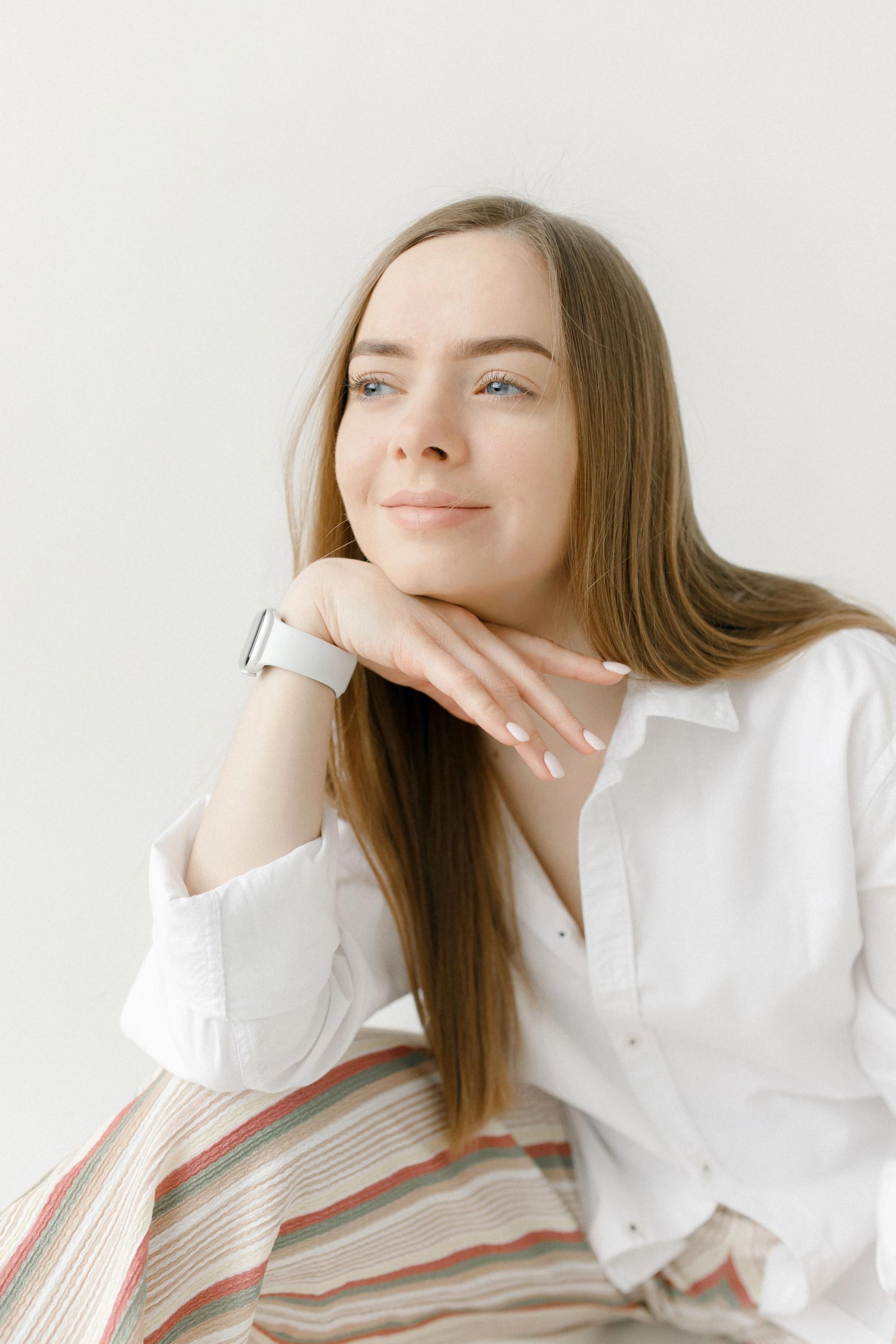 Close-up portrait of a woman resting her chin on her hand