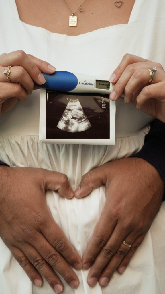 Hands holding a sonogram and pregnancy test