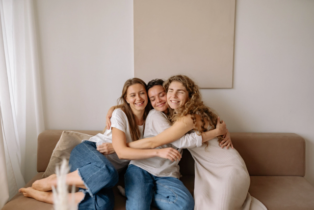 Three women smiling together outdoors