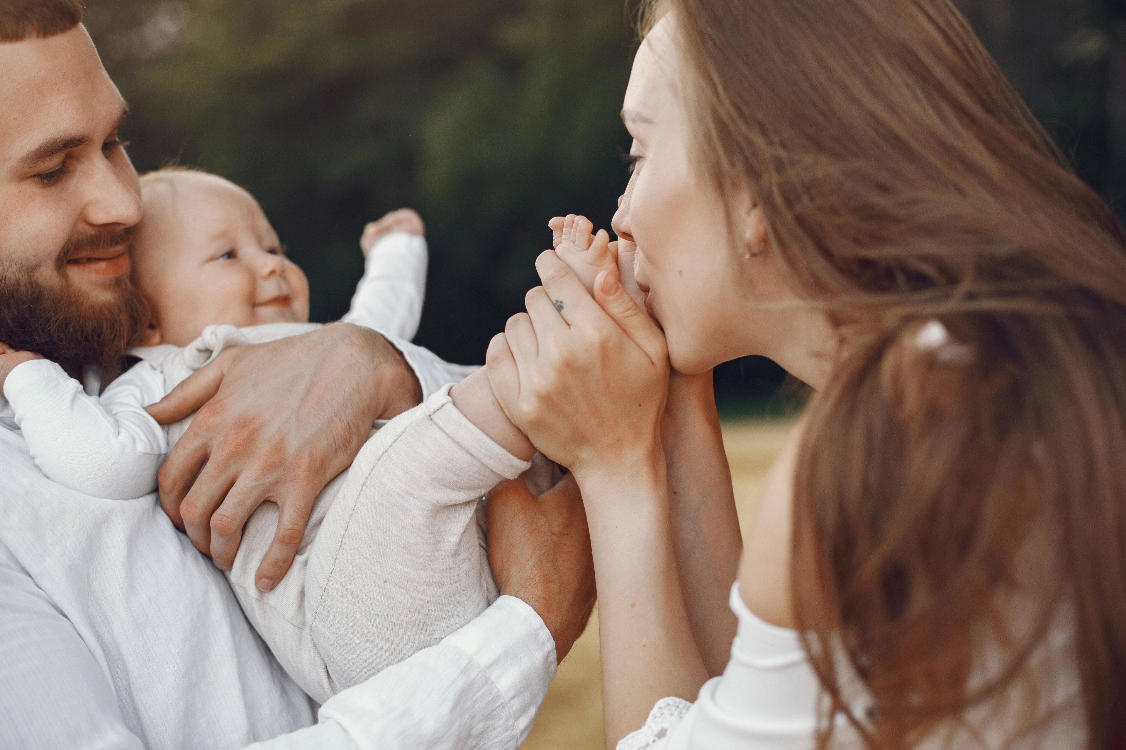 mother and father kissing baby's feet