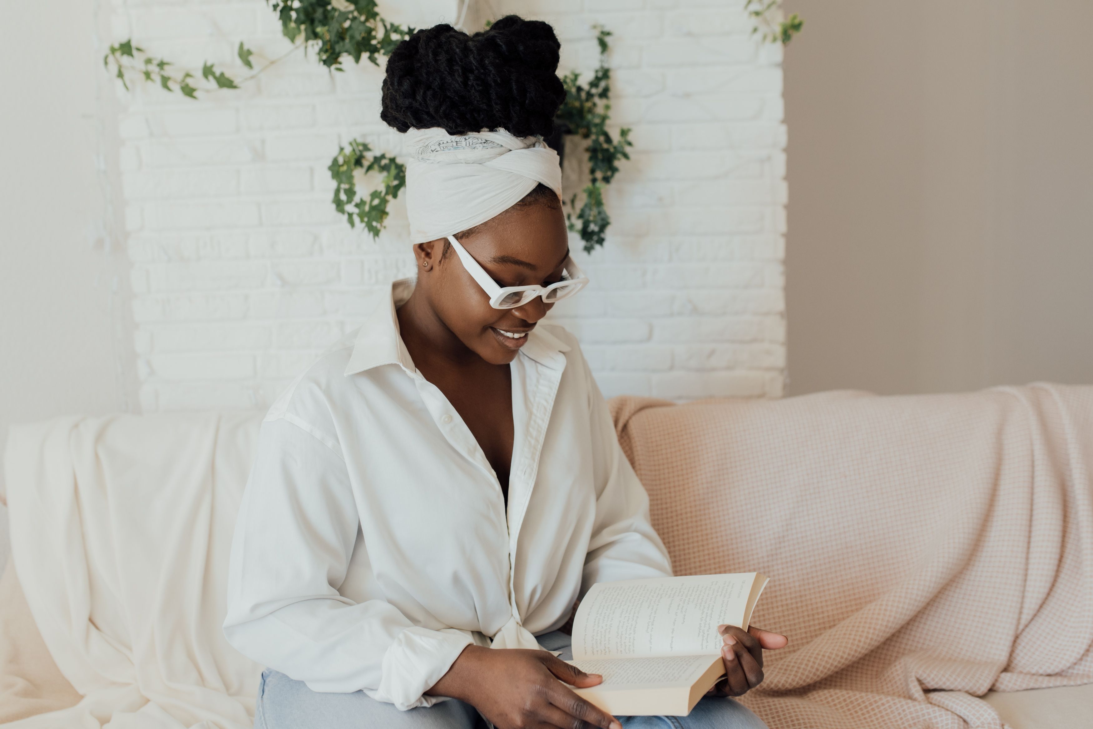 Woman in a white robe reading by a window