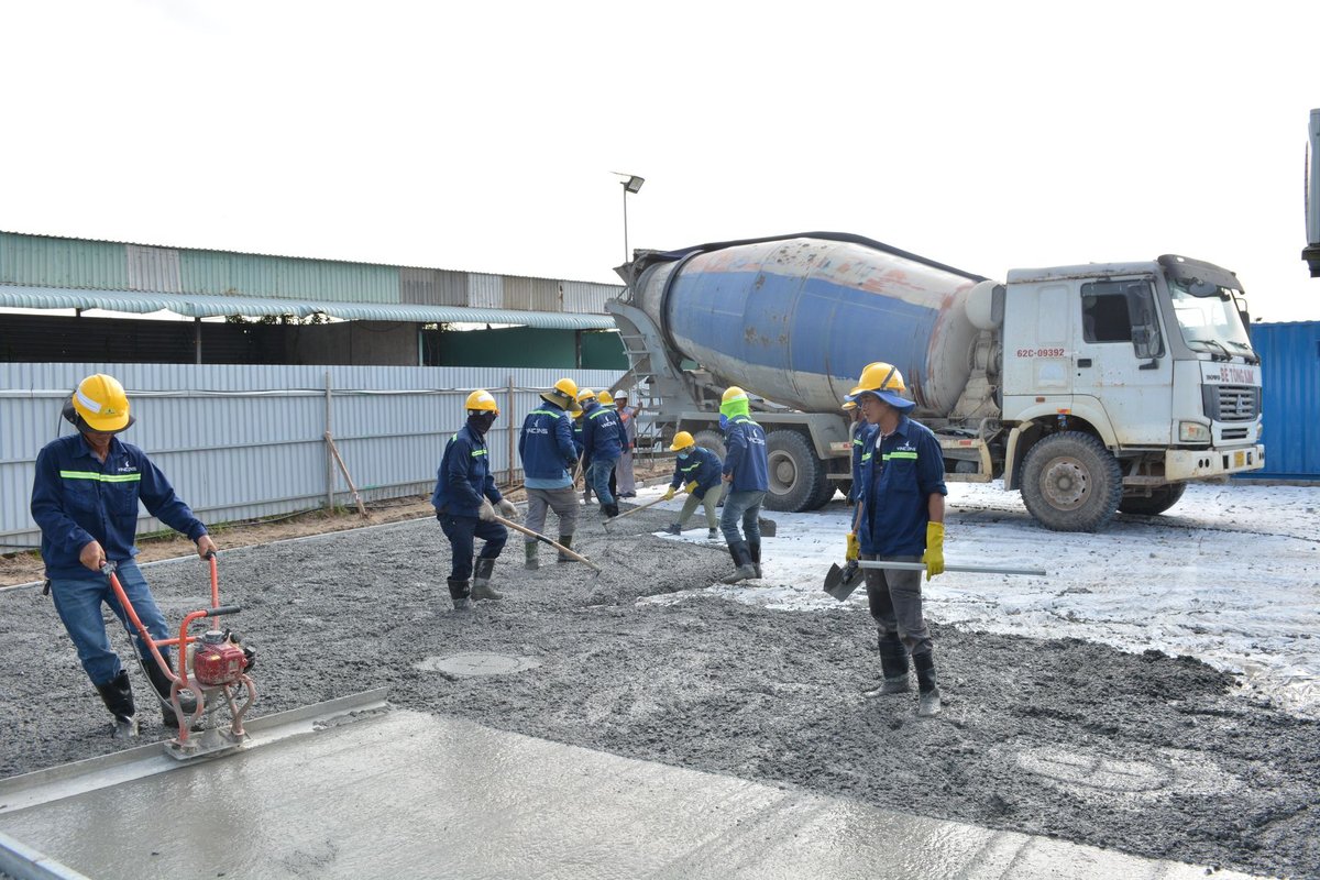 commercial concrete crew pouring slab with concrete mixer truck