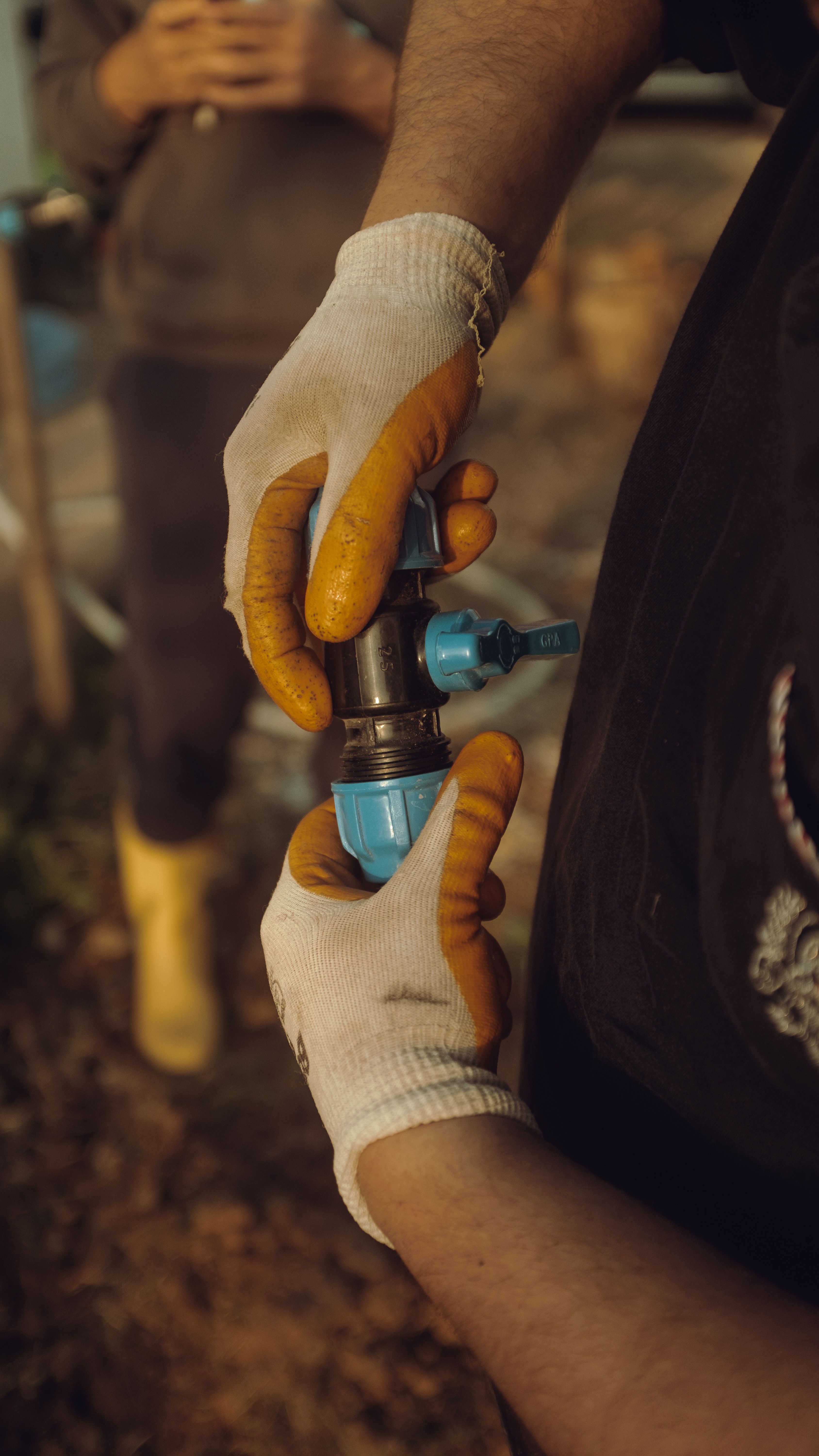 Close-up of hands assembling commercial irrigation piping outdoors