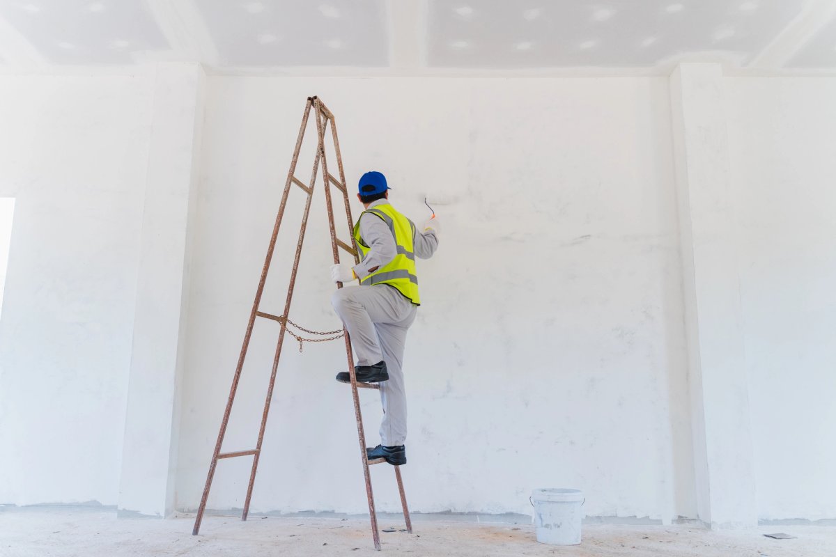 Commercial painter working on a large-scale interior coating project — Commercial Painting whitepaper cover