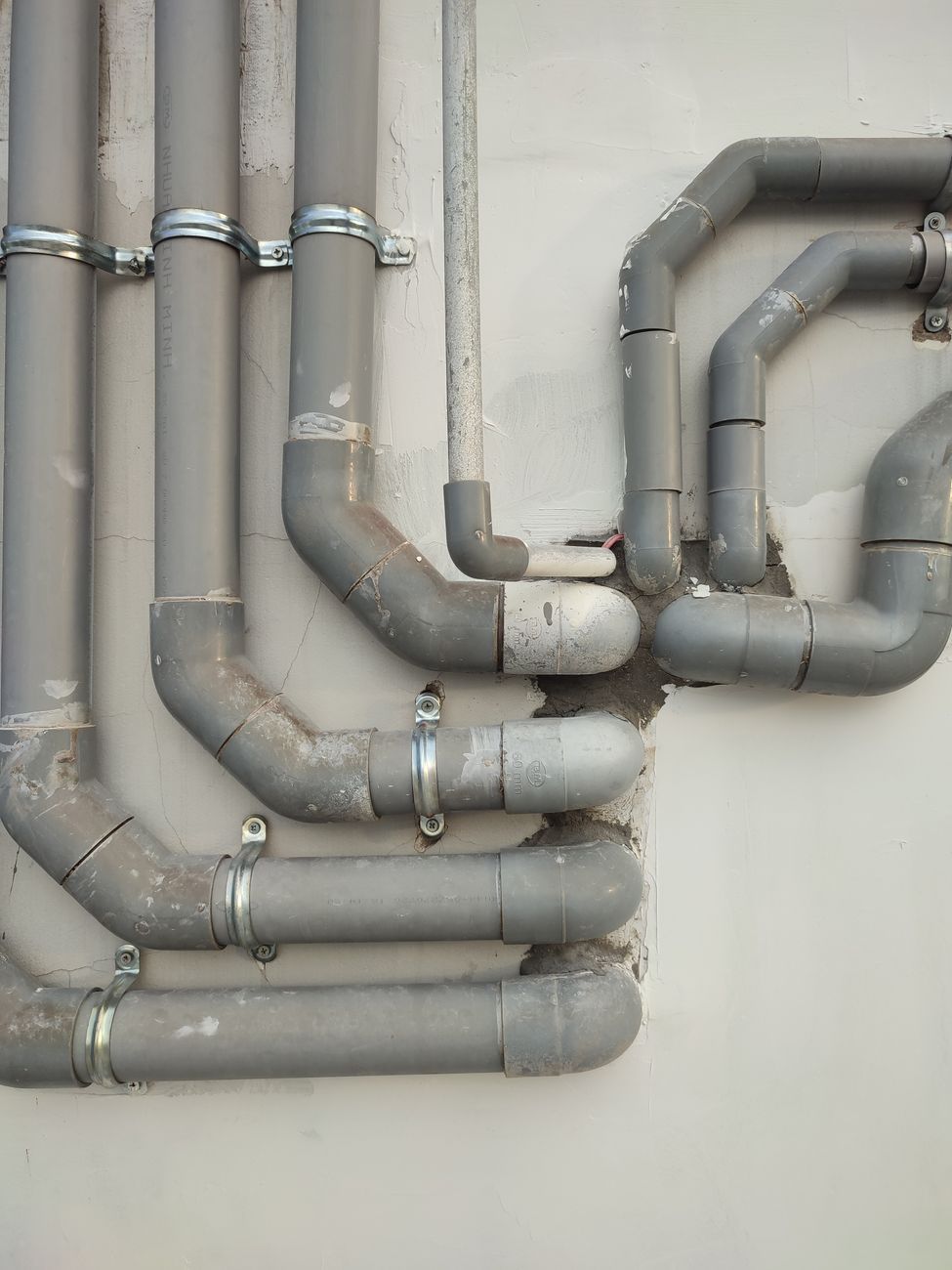 Commercial plumber working on pipe fitting, the kind of hands-on commercial-scale work this interview bank screens for.