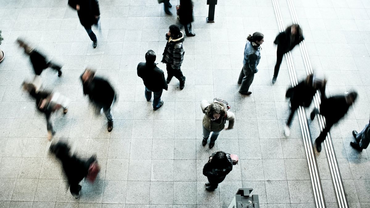 Bird's eye view of people rushing through a train station.