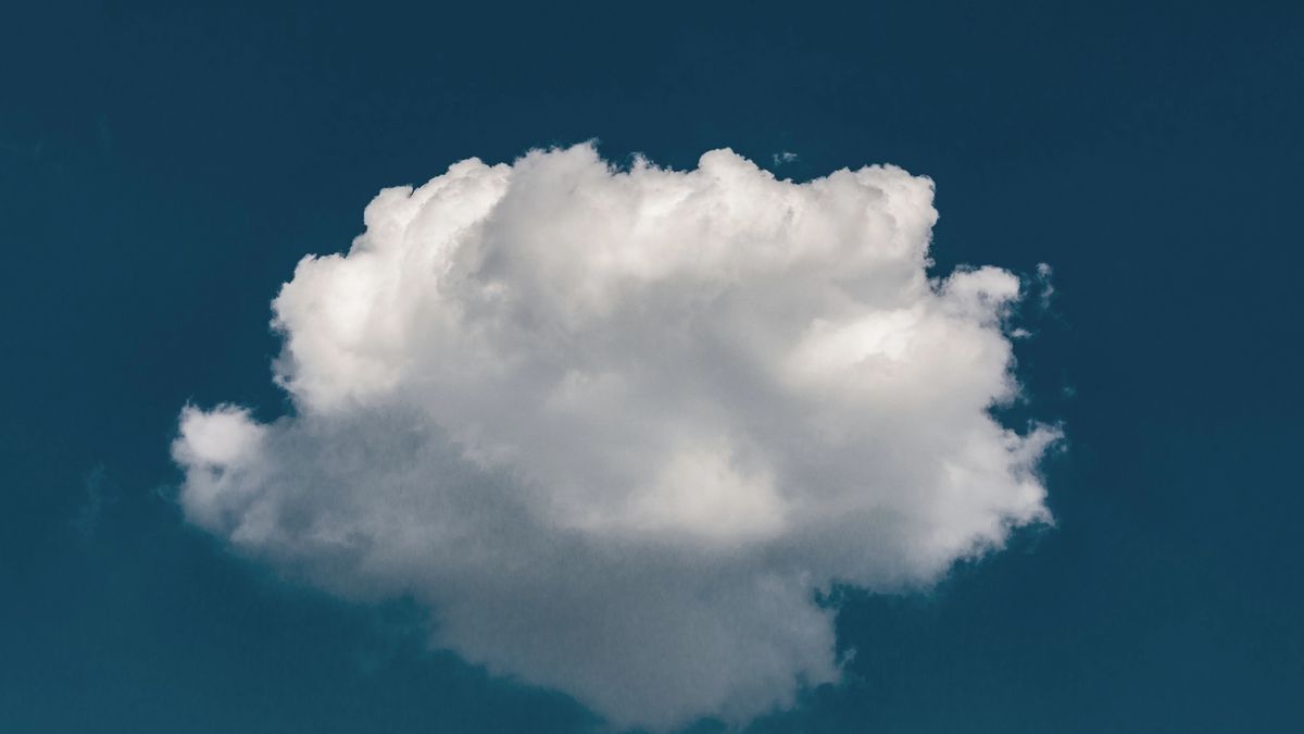 Single white, fluffy cloud against a blue sky.