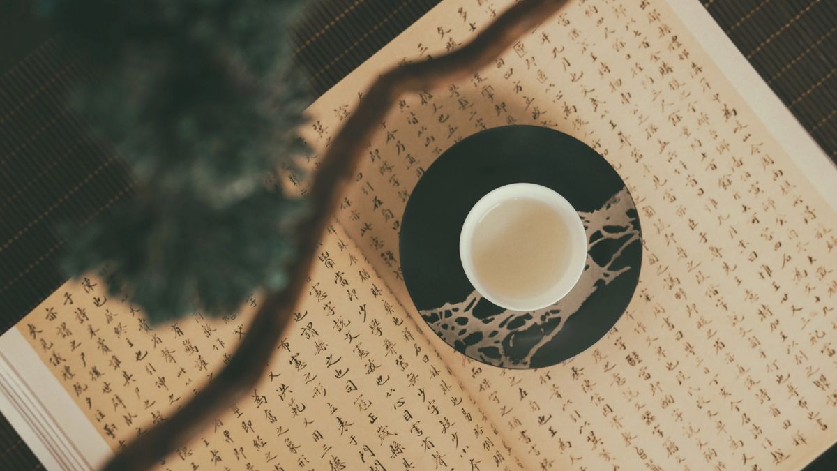 Cup of tea on top of a book in Chinese.