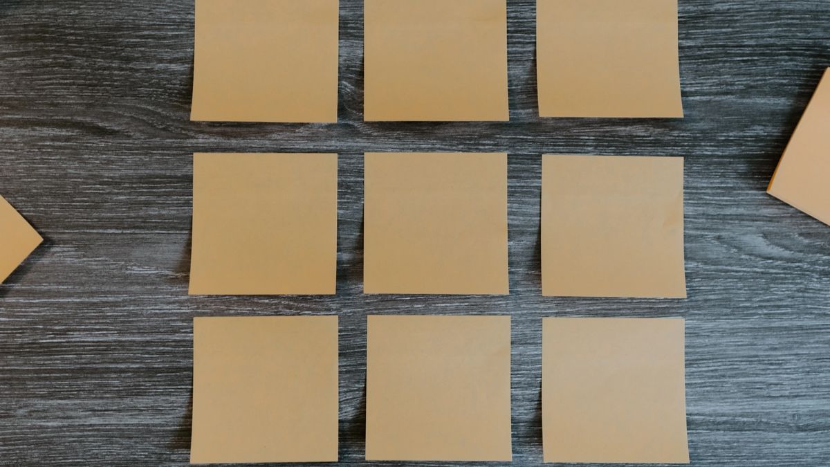 Orange post-it notes on a wooden desk.