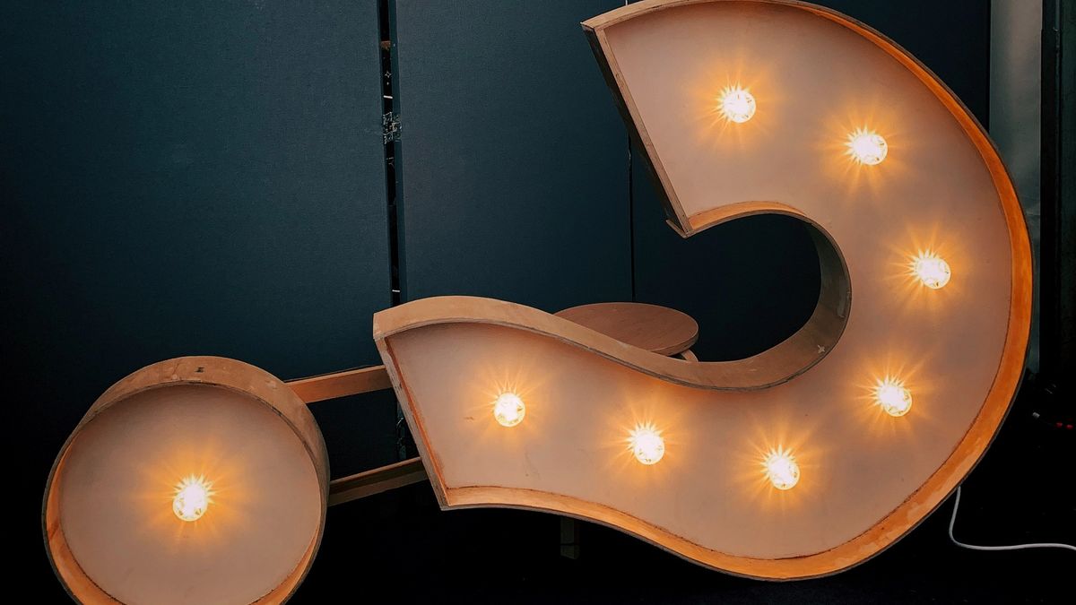 Vintage question mark sign with light bulbs, lying on its side.