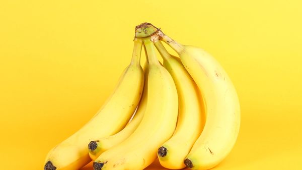 Bunch of bananas on a yellow background.