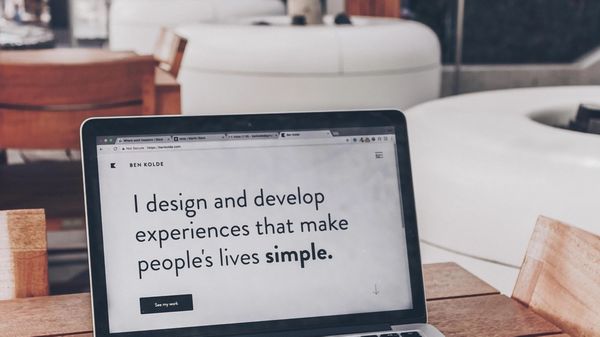 MacBook that reads "I design and develop experiences that make people's lives simple."