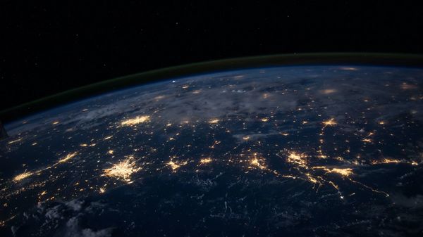 View of Earth from space at night, showing clustered lights.
