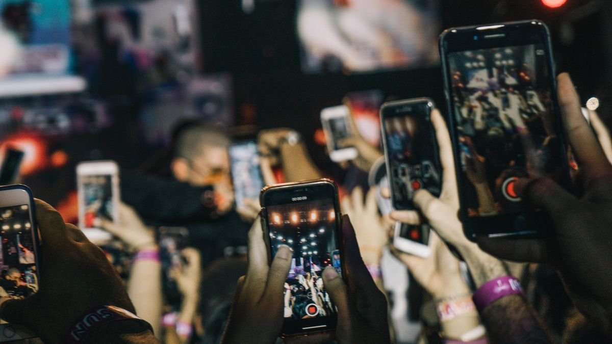 A sea of phone screens blocking a view of a show.