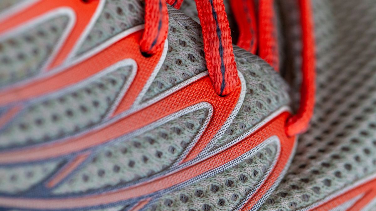 Close up of a grey running trainer with red laces.