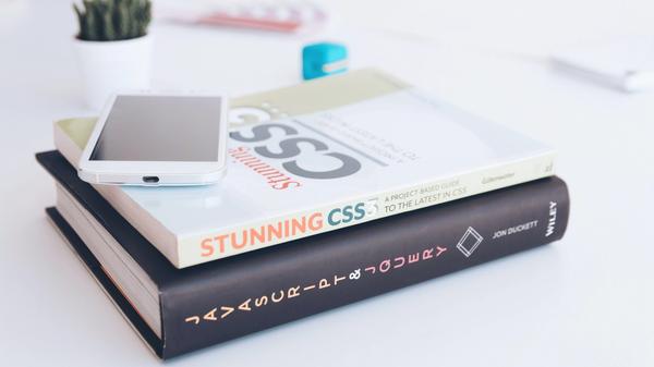 A mobile phone on top of Stunning CSS and Javascript & JQuery books.